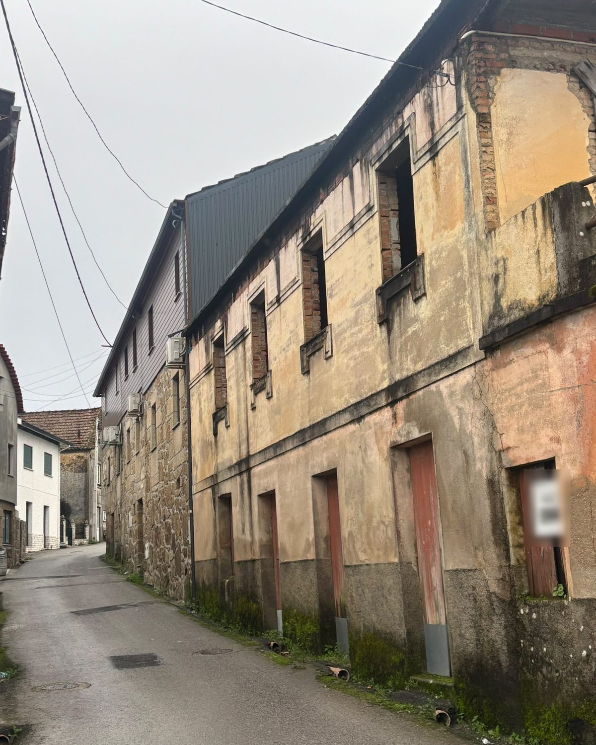 Antes: casa de dois pisos numa rua estreita, com o reboco velho e manchado