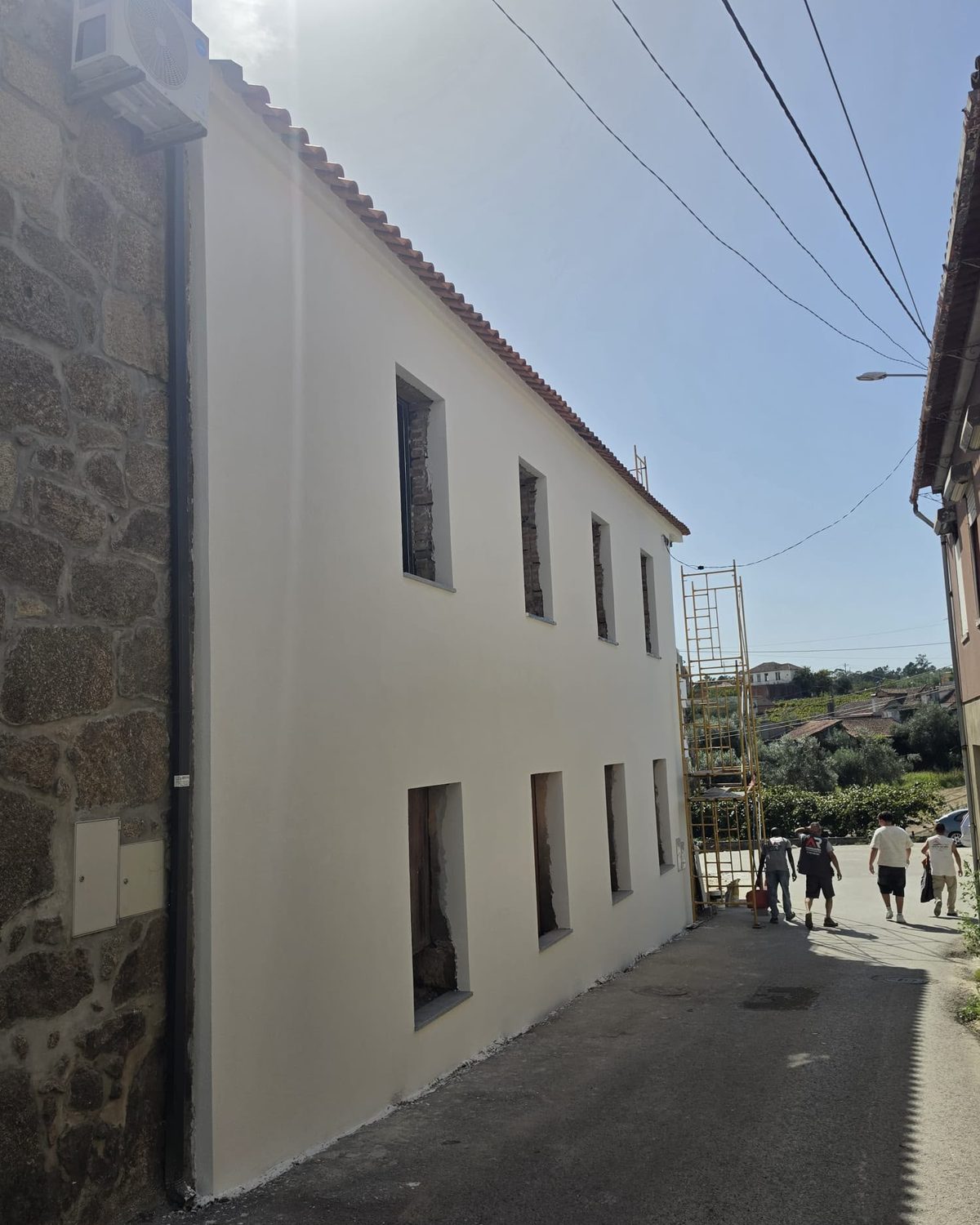 Depois: a fachada remodelada, rebocada e pintada de branco