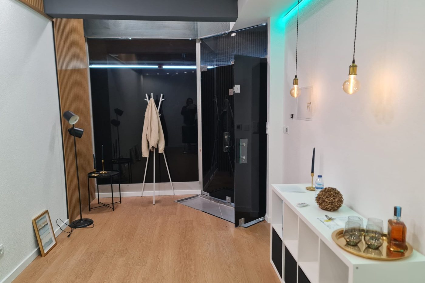 Interior remodelado: pavimento de madeira, parede com ripado, teto com iluminação embutida e candeeiros suspensos